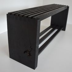 a bench made out of black wood on a white surface