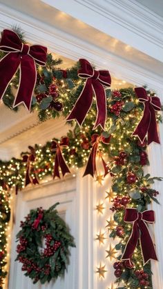 christmas wreaths are hung on the front door with red bows and lights around them