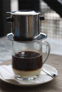 there is a coffee pot on top of a saucer with liquid in the bottom