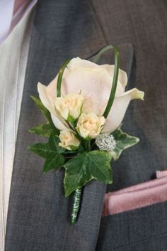 a man wearing a suit and tie with a boutonniere on his lapel