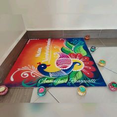 a colorful mat on the floor with decorative decorations around it and an inscription that reads happy diwali