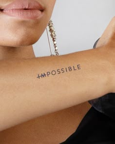 a woman's arm with the word impossible written on it