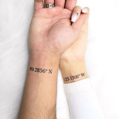 two people with matching tattoos on their wrists, one is holding the other's hand