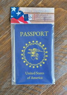 a passport sitting on top of a wooden table next to a piece of paper with an american flag