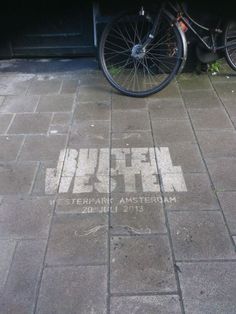 a bicycle parked next to a building with graffiti written on it's side and the words uttel in white