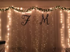 the curtain is decorated with lights and garlands for a wedding reception or special event