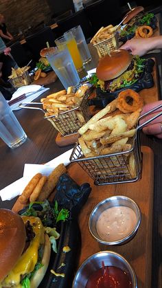 several baskets filled with food sitting on top of a wooden table next to other foods