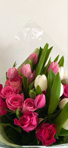 a bouquet of pink and white tulips in a clear vase