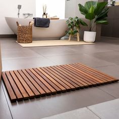 a bathroom with a bathtub and wooden flooring in it's center area