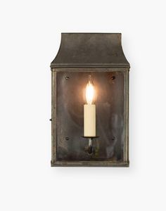 an old fashioned wall light with a single candle on it's front and side