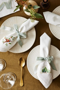 the table is set with white plates and silverware