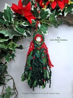 a christmas ornament hanging from a tree with poinsettia and holly