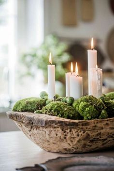 a bowl filled with moss and lit candles