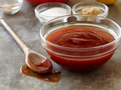 a bowl filled with sauce next to a spoon