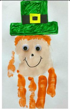 a child's handprint with a green hat and orange carrots on it