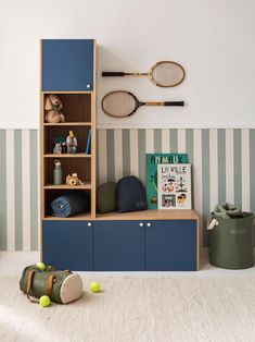 a tennis racket is hanging on the wall above a bookshelf in a child's room