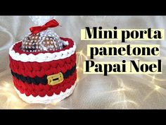 a crocheted santa hat sitting on top of a white sheet with the words mini porta panetoe papai noel