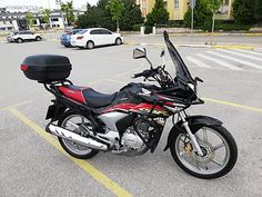 a red and black motorcycle parked in a parking lot