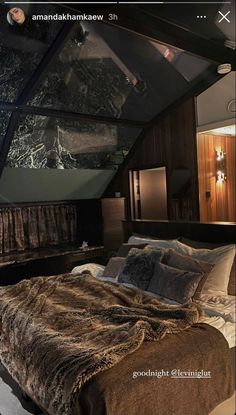 a large bed sitting in the middle of a bedroom next to a wall mounted tv