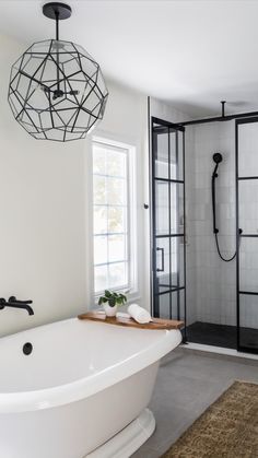 a white bathtub sitting next to a window in a bathroom on top of a rug