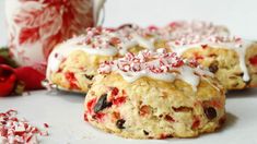 two cookies with white icing and peppermint on top next to a mug