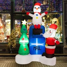 an inflatable snowman and santa clause on top of a building with christmas lights