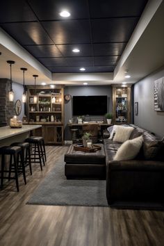 a living room filled with furniture and a flat screen tv mounted to the wall next to a bar