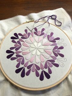 a purple and white flower is on the table next to a pair of yarns