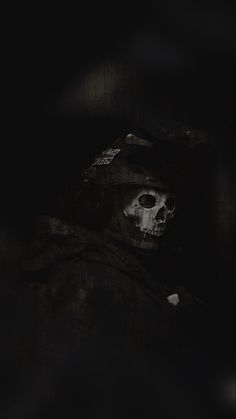 a person with a skull on their face in the dark