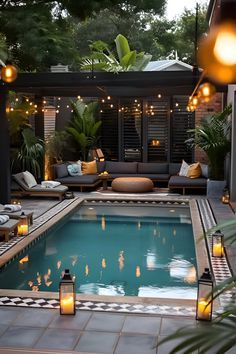 an outdoor pool surrounded by lights and furniture with candles on the side, next to a patio