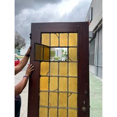 a person is holding up a window that has been stained yellow