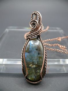 Handmade wire wrapped labradorite gemstone pendant. Labradorite is known for its captivating play of colour, shifting hues from blues and greens to flashes of gold.  Labradorite activates intuition, wisdom, clarity, creativity, and divination it helps to recognize positivity and hope. Each pendant is a one-of-a-kind piece of wearable art, making it the perfect statement accessory for those who appreciate the extraordinary.  This beautiful gemstone is wrapped in oxidized copper to give it a vinta Copper Jewellery, Handmade Wire Wrapped, Antique Style, Gemstone Pendant, Jewelry Care, Wearable Art, Labradorite, Jewelry Necklace Pendant, Jewelry Necklaces