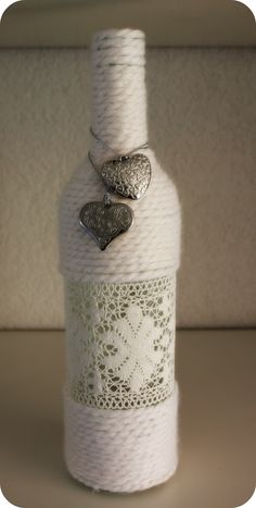 a white bottle with two hearts on it and some twine in front of it