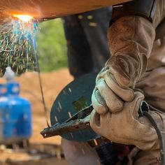 welder working on an object with sparks coming out of the back and inside it