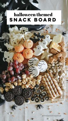 halloween themed snack board with cookies, crackers and candies on the table top