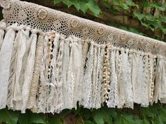 an old lace curtain hanging from a tree