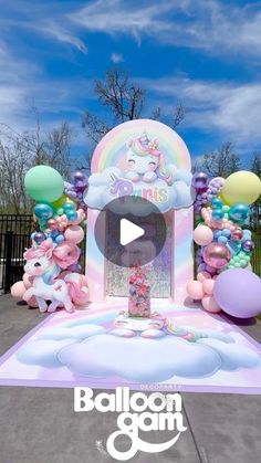 an inflatable balloon arch with unicorns and balloons on the ground next to it