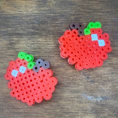 two red and green buttons sitting on top of a wooden table next to each other