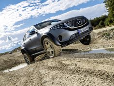 the mercedes benz suv is driving through mud