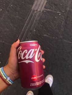 a person holding a can of coca cola