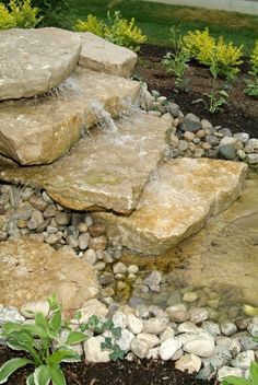 a garden with rocks and water running down it