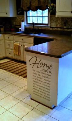 a kitchen island with a sign on it in front of the sink and countertop