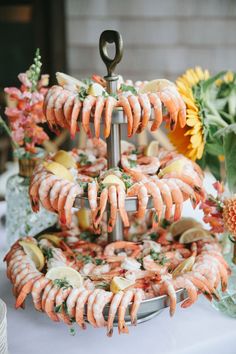 an assortment of food is displayed on a platter with flowers and other items in the background