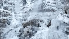 a waterfall is covered in ice and snow