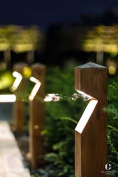 three wooden posts with lights shining on them