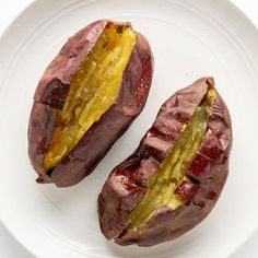 two pieces of food on a white plate next to one piece of bread and the other part of an eggplant