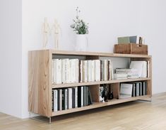 a bookshelf filled with lots of books on top of a hard wood floor