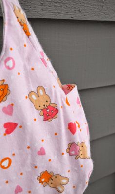 a baby bib hanging from the side of a house with hearts and bears on it