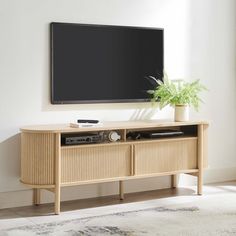 a flat screen tv sitting on top of a wooden entertainment center