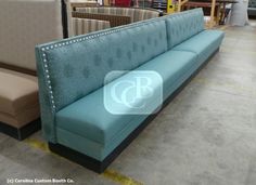 a blue couch sitting on top of a floor next to other furniture in a store